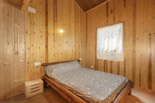 a bedroom with a bed in a wooden room at Bungalow Alós in Alós de Balaguer