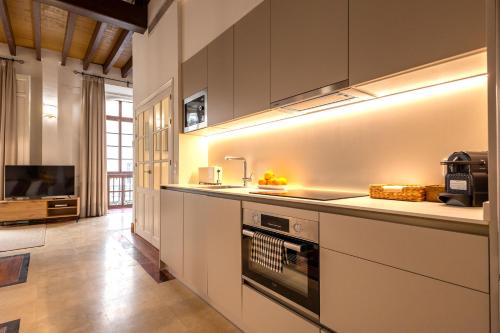 a kitchen with white cabinets and a stove top oven at Casa Rental home Campana in Seville