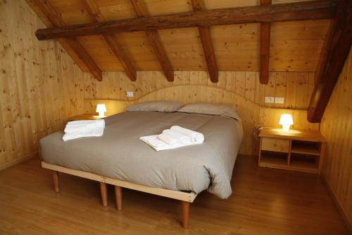 a bedroom with a bed in a wooden cabin at Casa Di Ettore e Luigina in Ovaro