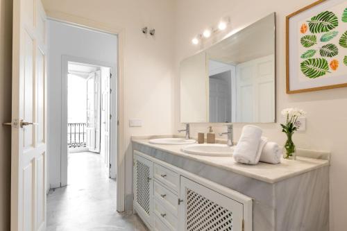 a bathroom with two sinks and a large mirror at Casa Rental home Campana in Seville