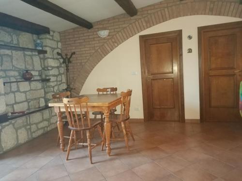 uma sala de jantar com uma mesa de madeira e cadeiras em Deattellis House Casa vacanza em Campobasso