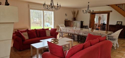 - un salon doté d'un mobilier rouge et d'une table dans l'établissement Domaine des Aulnaies - Beauval - Mareuil sur Cher, à Mareuil-sur-Cher