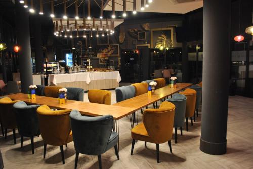 a long wooden table and chairs in a restaurant at Hotel Bastion in Malbork