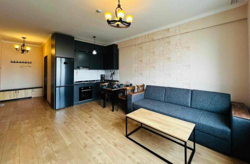 salon z niebieską kanapą i kuchnią w obiekcie Cosy modern city apartment in UB w Ułan Bator