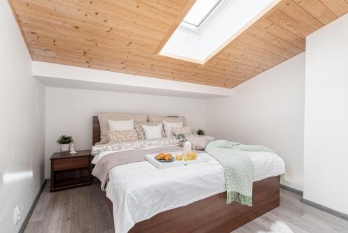 a bedroom with a bed with a tray of fruit on it at Lipno Korzo Residence in Lipno nad Vltavou