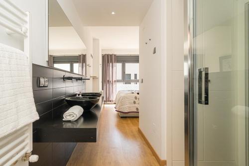 baño con lavabo negro y cama en Pegaso Playa de Albir, en Albir