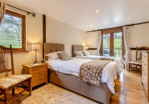 TrefeglwysにあるDerw Lodgeの広いベッドルーム(ベッド2台、窓付)