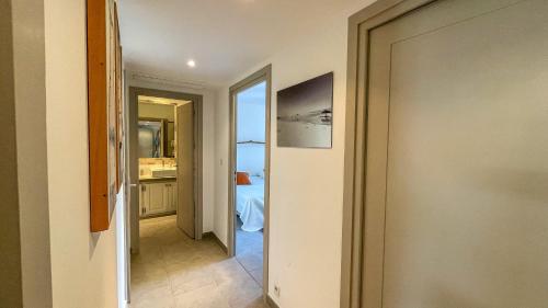 un couloir avec une porte menant à une chambre dans l'établissement Appartement Le Pinarello, à Sainte-Lucie de Porto-Vecchio