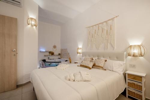 - une chambre blanche avec un grand lit blanc et 2 oreillers dans l'établissement Dimora Giulia, luxury suite and spa, à Castellana Grotte