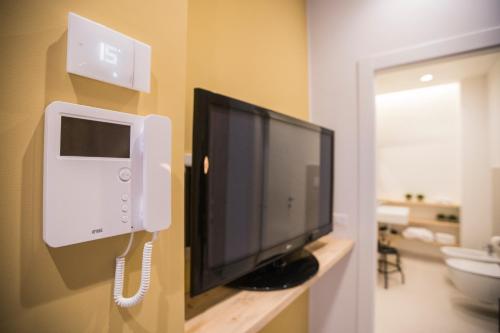 a flat screen tv on a wall with a phone at Albergo Diffuso Dimora Rossi Suite B&B in Turi