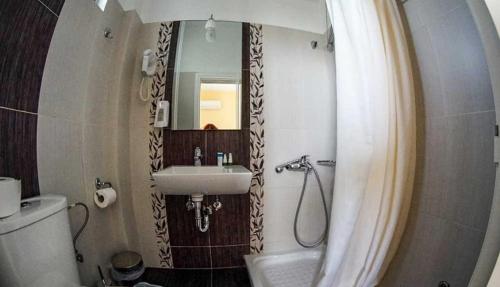 a bathroom with a sink and a toilet and a mirror at GOLDEN SUN in Vrachati