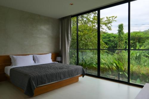 a bedroom with a bed and a large window at Greenery Concierge in Mu Si
