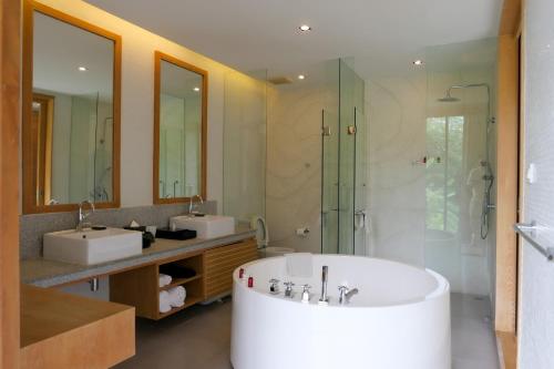 a bathroom with a tub and two sinks and a shower at Greenery Concierge in Mu Si