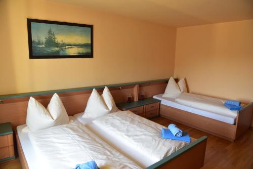 two beds in a room with blue towels on them at Stiftsgasthof Hochburg in Hochburg-Ach