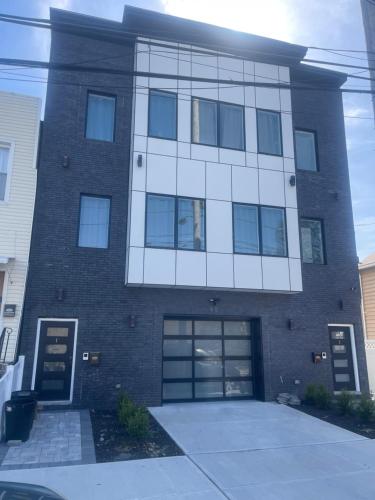 um grande edifício de tijolos com duas portas de garagem em luxurious big house em Jersey City