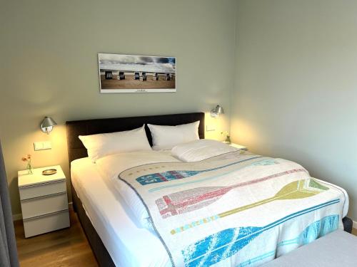 ein Schlafzimmer mit einem großen Bett mit einer Decke darauf in der Unterkunft Skipper Lounge 17.2 inkl. TG-Platz in Heiligenhafen