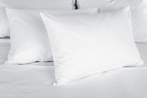 an unmade bed with white pillows on it at The Originals Access Aéroport, Hôtel Aurillac in Aurillac