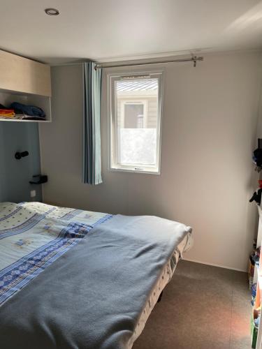 Schlafzimmer mit einem Bett und einem Fenster in der Unterkunft Mobil home charmant in Argelès-sur-Mer