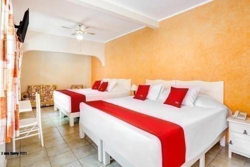 a bedroom with two beds with red and white sheets at Los Anturios in Cuernavaca