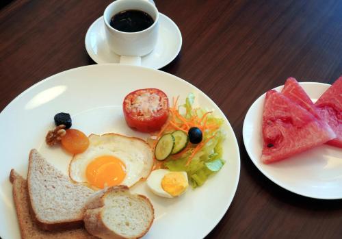 a plate of breakfast food with eggs and bread and a cup of coffee at Escale International Hotel in Djibouti