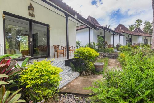 a house with a garden and a patio at Radjes Bungalow Nusa Penida in Nusa Penida