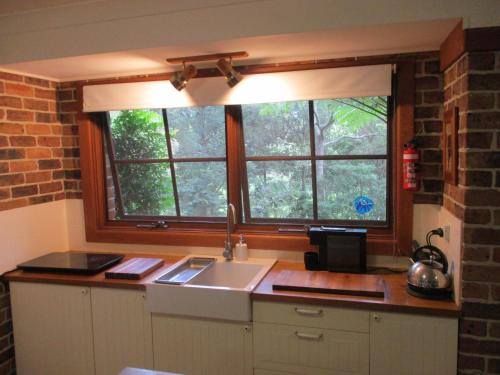a kitchen with a sink and a window at Warriwul Farmland Rural Retreat BnB, Curramore/Jamberoo in Jamberoo