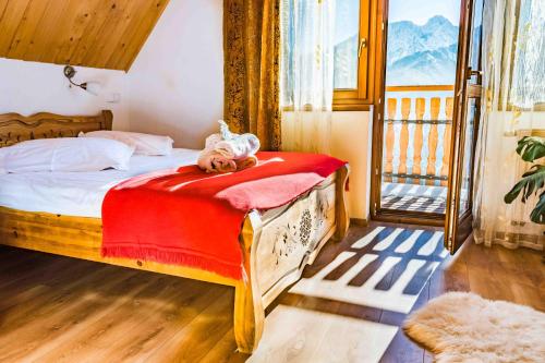 a bedroom with a bed with a teddy bear on it at Górski Pałacyk Kompleks obiektów in Kościelisko