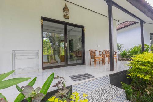 a house with a patio with a table and chairs at Radjes Bungalow Nusa Penida in Nusa Penida