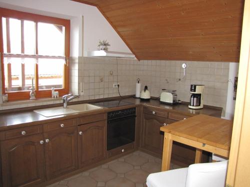 una cocina con armarios de madera y fregadero en LandLiebe, en Tännesberg