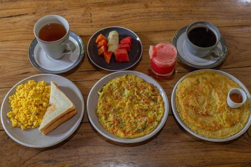 four plates of food on a table with breakfast foods at Radjes Bungalow Nusa Penida in Nusa Penida