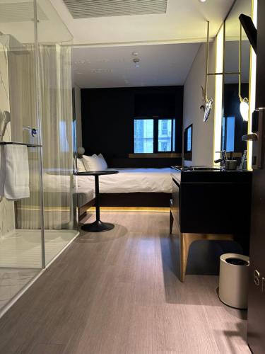 ein Schlafzimmer mit einem Bett und einem Schreibtisch sowie ein Badezimmer in der Unterkunft CitiGO Hotel Lujiazui Shanghai in Shanghai