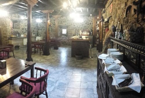 a restaurant with tables and chairs in a room at Hotel Rural Palacio de Galceran in Sotiello