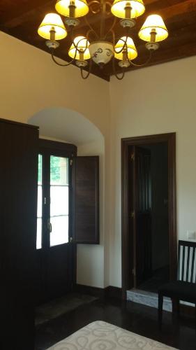 a room with a chandelier and a door with a window at Hotel Rural Palacio de Galceran in Sotiello