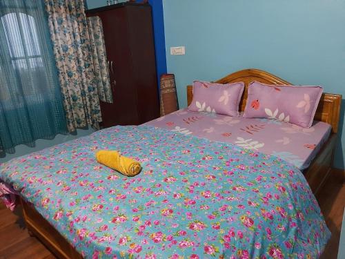 een bed met een sprei met bloemen erop bij Chewang Homestay in Darjeeling