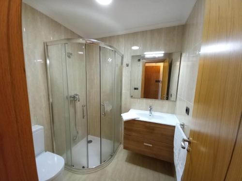 a bathroom with a shower and a sink and a toilet at Marina in Ribeira