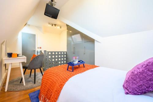 una camera con letto, scrivania e sedia di 2 bed with terrace - Llandaff Lofts by Tŷ SA a Cardiff