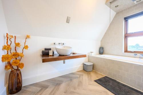 a bathroom with a sink and a bath tub at 2 bed with terrace - Llandaff Lofts by Tŷ SA in Cardiff