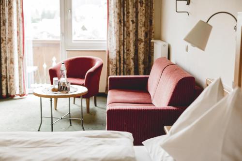 a hotel room with a couch and a table at Hotel Post Abtenau in Abtenau