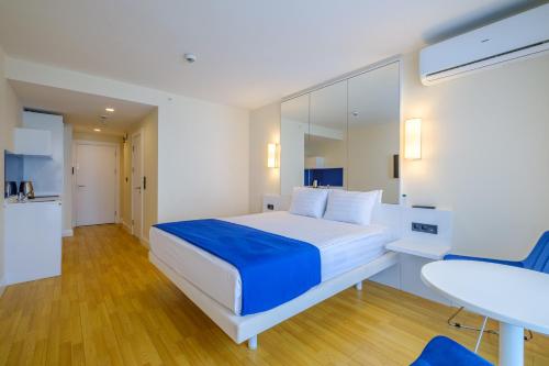 a bedroom with a large bed with a blue blanket at Orbi City Hotel Official in Batumi