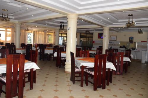 un comedor con mesas y sillas en un restaurante en Hotel Winstar en Eldoret