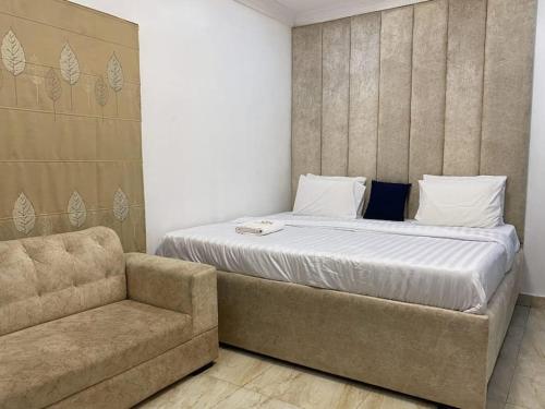 a bed in a room with a couch next to it at Zek's Place in Lagos