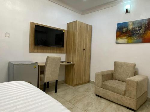 a bedroom with a desk and a chair and a television at Zek's Place in Lagos