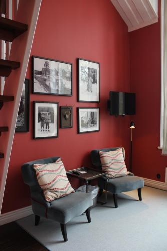 a red living room with two chairs and a table at Olarsgården Hotell in Lindvallen
