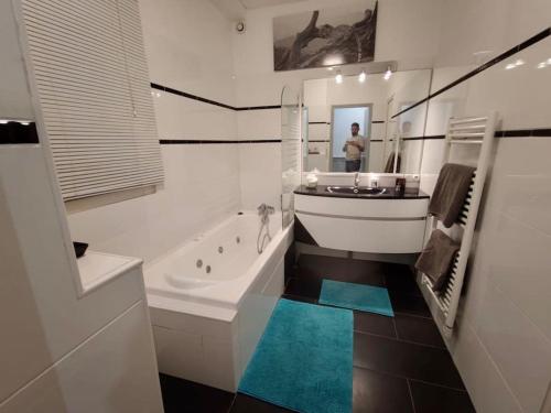een witte badkamer met een bad en een wastafel bij Super T3 centre historique près halles in Bayonne