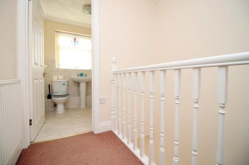 a hallway with a bathroom with a toilet and a sink at 3 Bed with Free Parking - Merriotts 1 by Tŷ SA in Newport