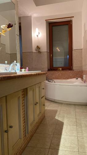 a bathroom with a tub and a sink and a bath tub at Luxury Room Cosenza in Cosenza
