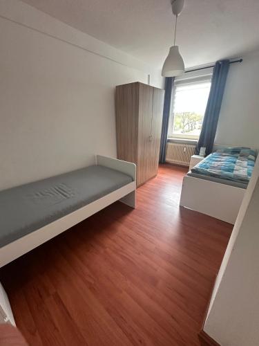 a room with two beds and a wooden floor at Domum 7 Ferien- Monteurapartments inkl Wlan und Waschmaschine in Kamen in Kamen