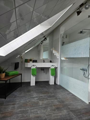 a bathroom with two green towels and a mirror at Mittel-Schänke Wieda in Walkenried