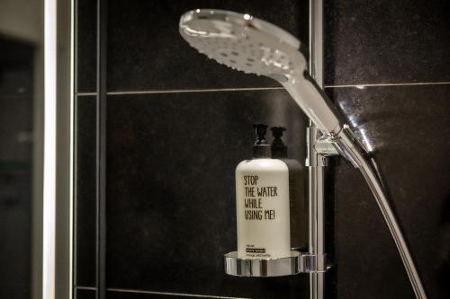 um chuveiro com uma garrafa de sabão na casa de banho em The Cloud One Prague em Praga