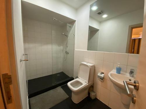 een badkamer met een toilet, een wastafel en een spiegel bij Hovah Luxury Homes' 2BR Apartment in Accra
